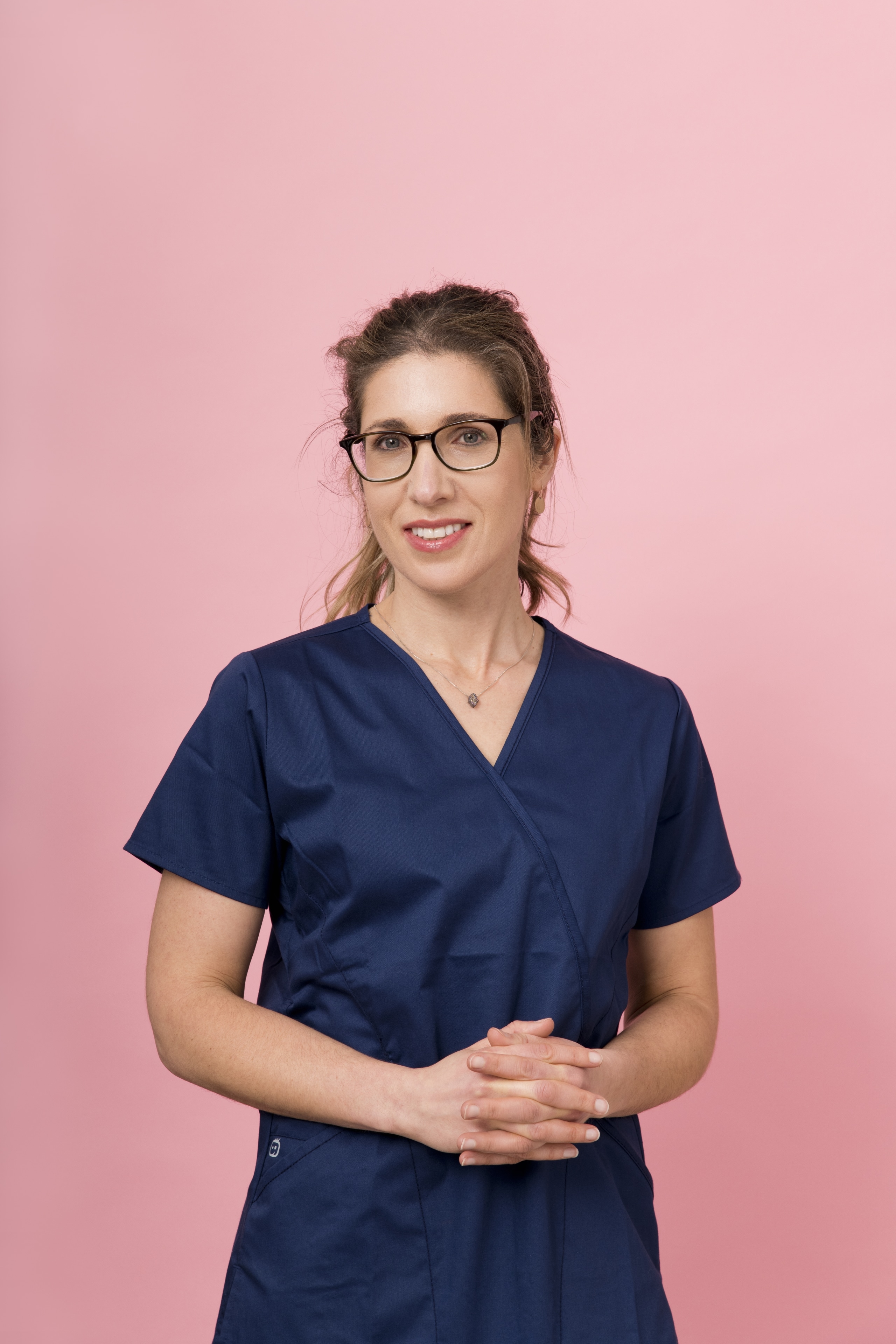 Fellow in scrubs against pink background