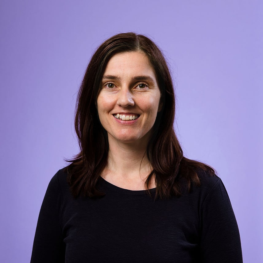 Carly Moorfield, Training Support Liaison, smiling at the camera against a purple background