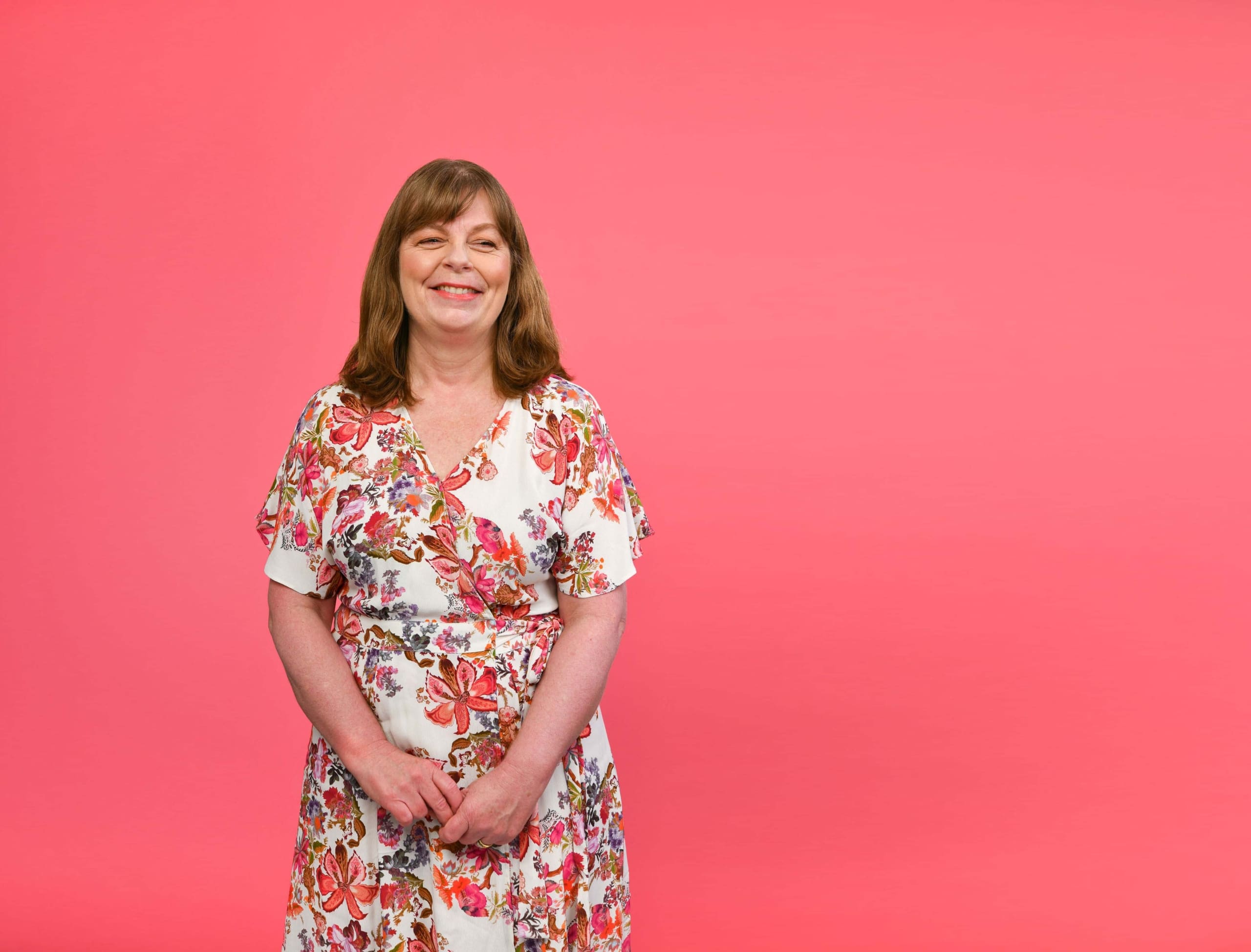 A portrait of Fellow Dr Debbie Nisbet against a pink background